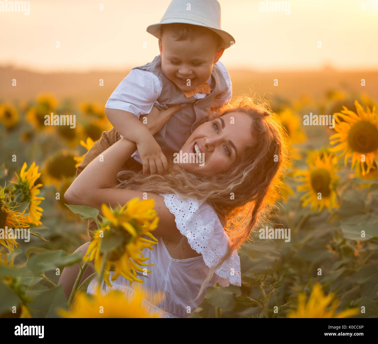 Mother with baby son in sunflower field Stock Photo - Alamy