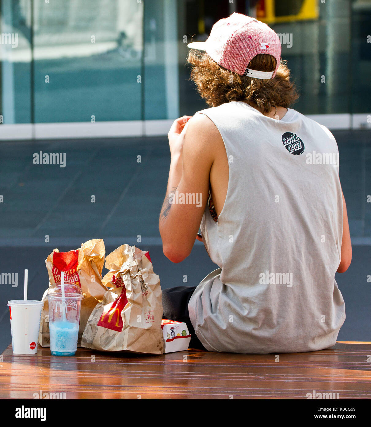 rear view of young adult eating fast food Stock Photo - Alamy