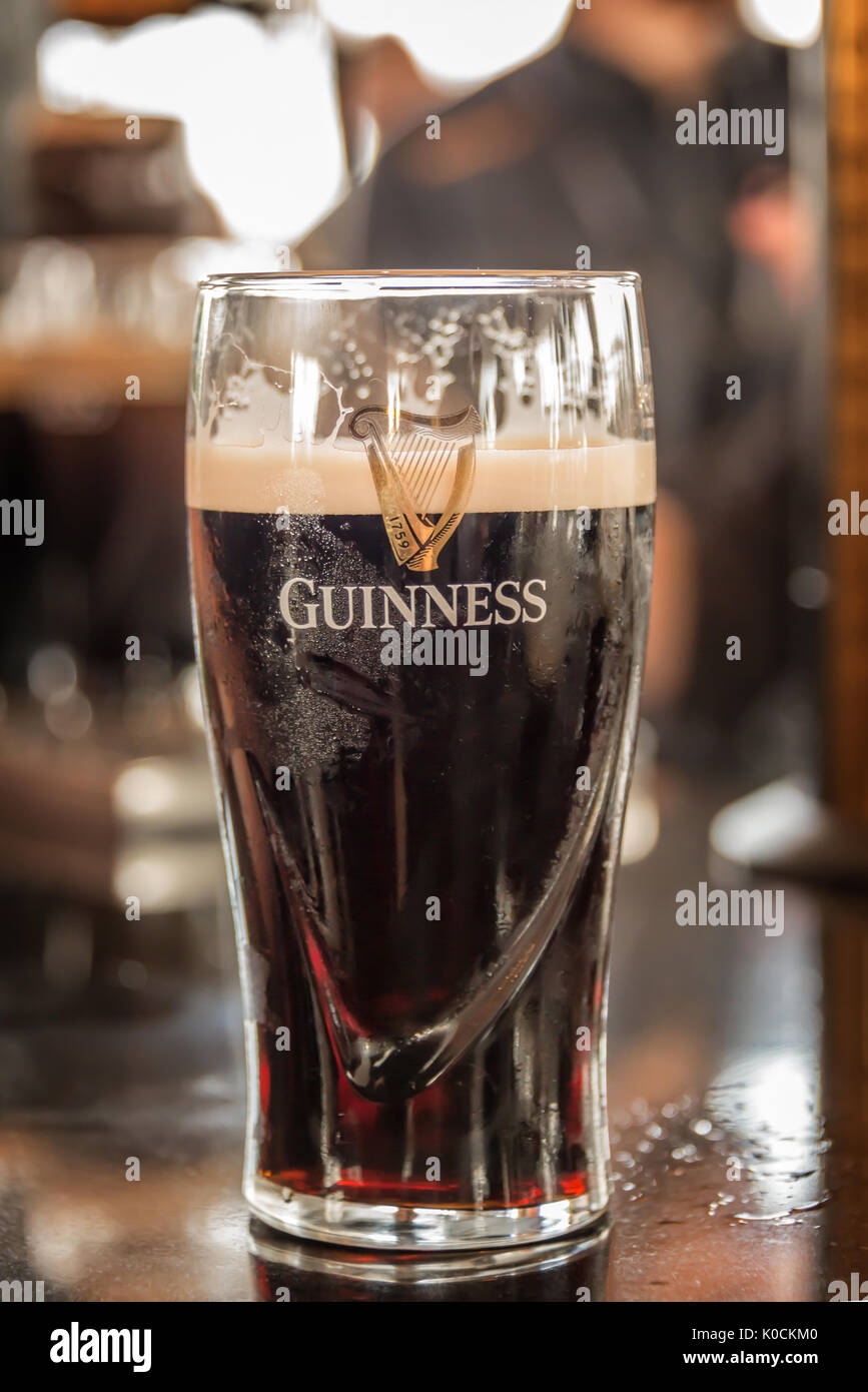 DUBLIN, IRELAND - AUGUST 14: Close up of a glass of Guinness stout beer on a bar counter in Dublin, Ireland Stock Photo