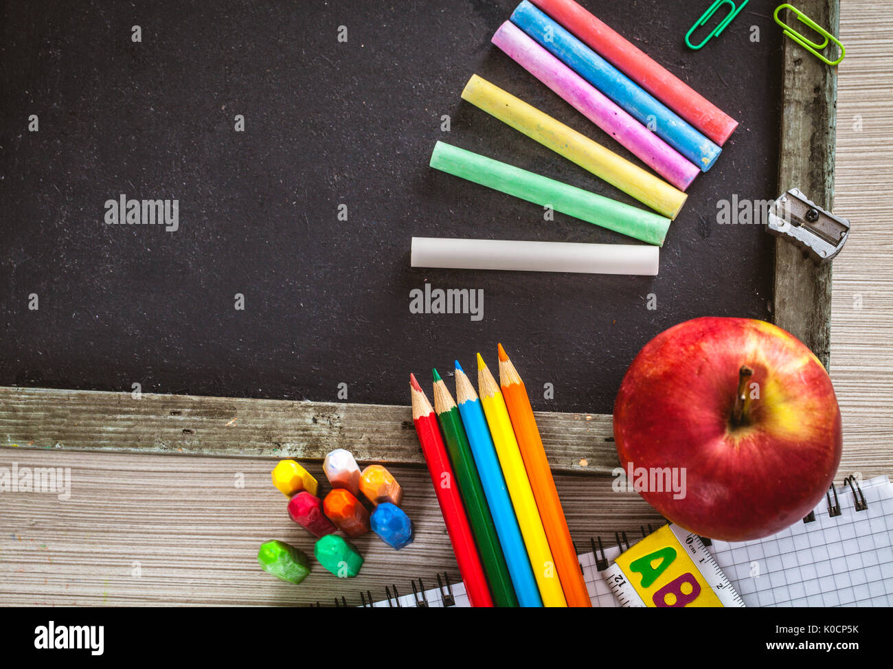 School objects for students. Chalkboard, pencils, crayons and apple Stock  Photo - Alamy