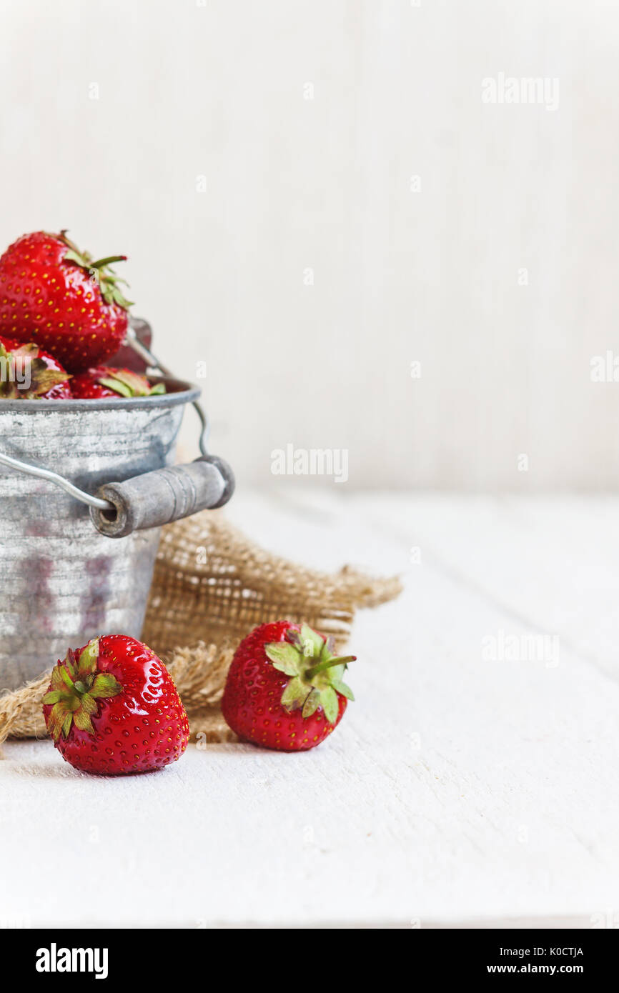 Fresh juicy strawberries in an old iron bucket on a white background ...