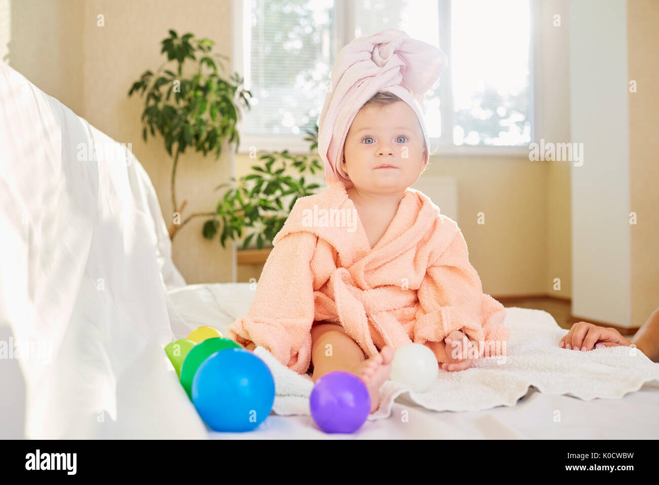 Baby child in the bathrobe and towel on his head after bathing i Stock Photo