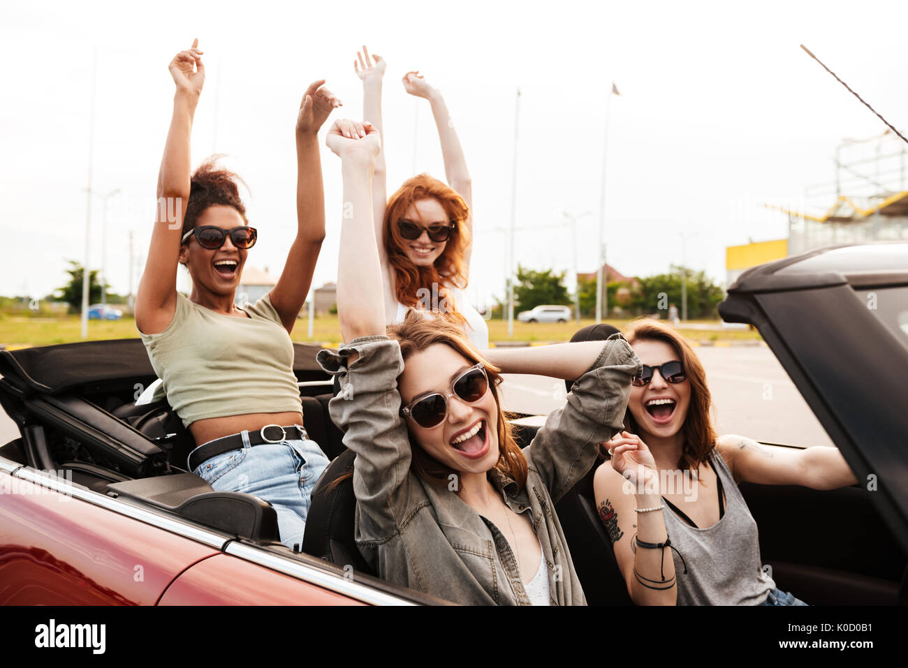 Picture of happy emotional four young women friends sitting in car ...