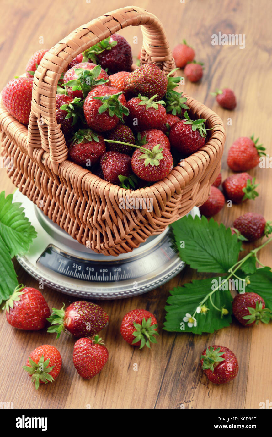 Basket of Strawberries on weight scale at wooden table background Stock Photo Alamy