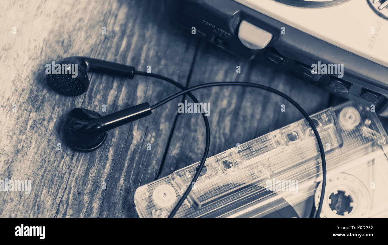 Vintage walkman cassette player with earbuds and tape cassette, retro style toned image Stock Photo