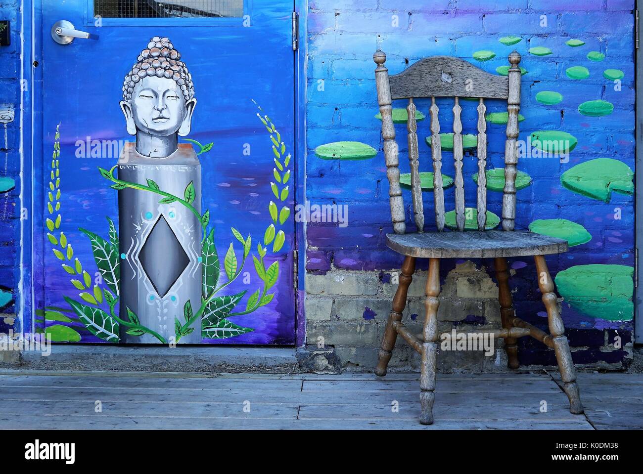 buddha mural next to chair against wall (colour) Stock Photo