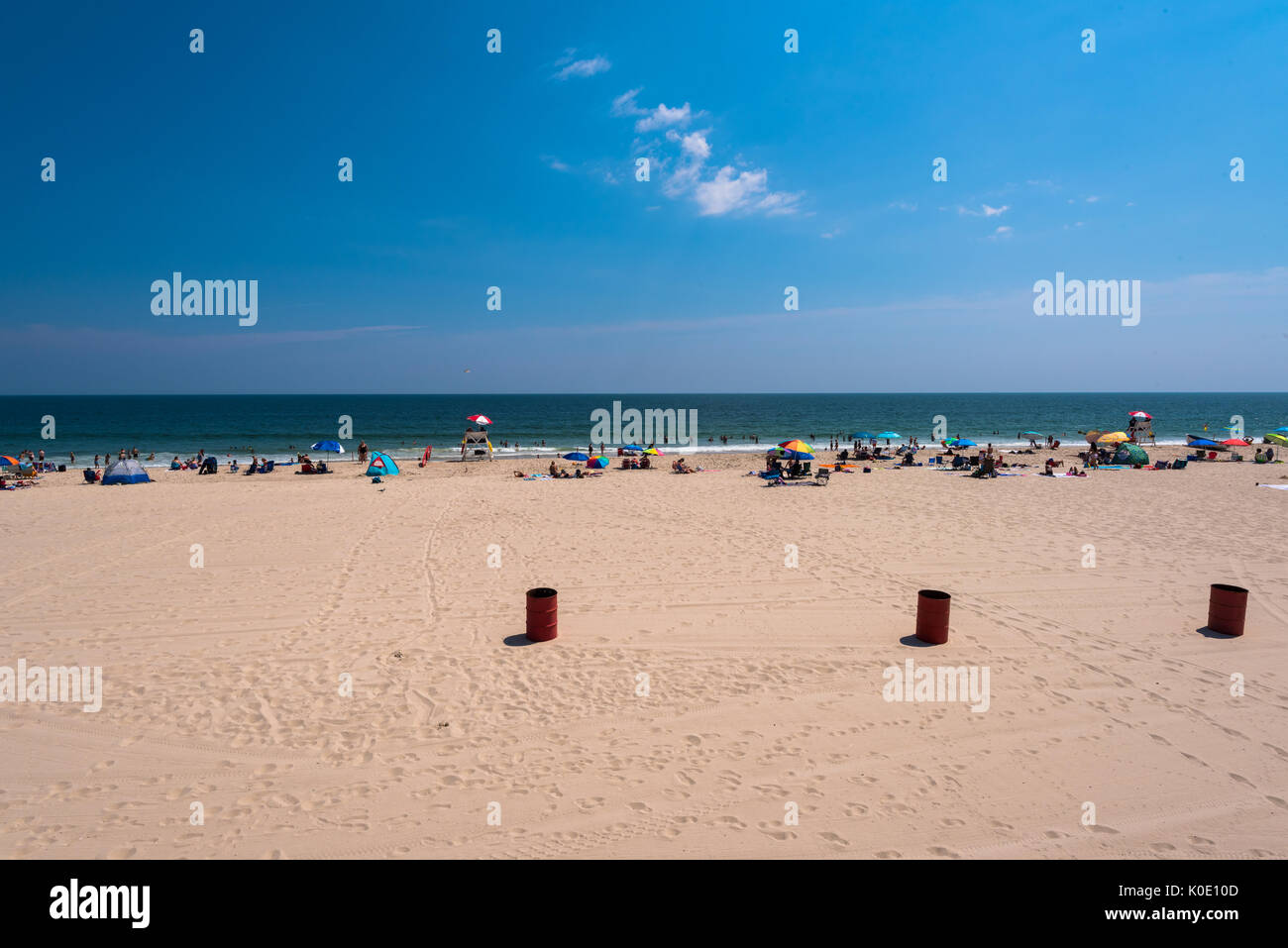 Sunbathers relax on a bright sunny day on the Seaside beach at the Jersey Shore. Stock Photo