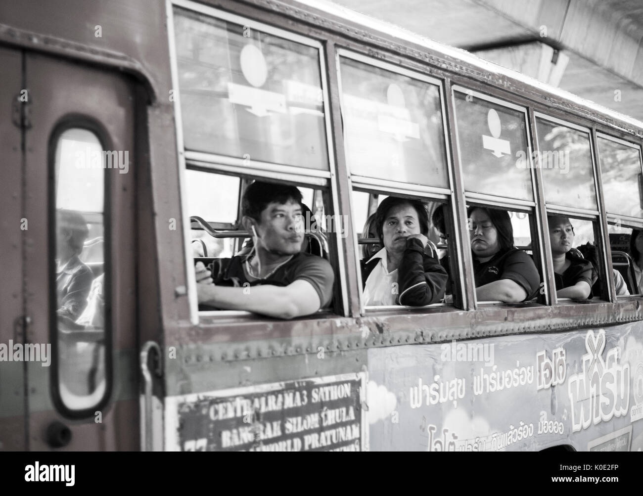 Thailand, Bangkok/ Passengers look out the window of a bus Stock Photo