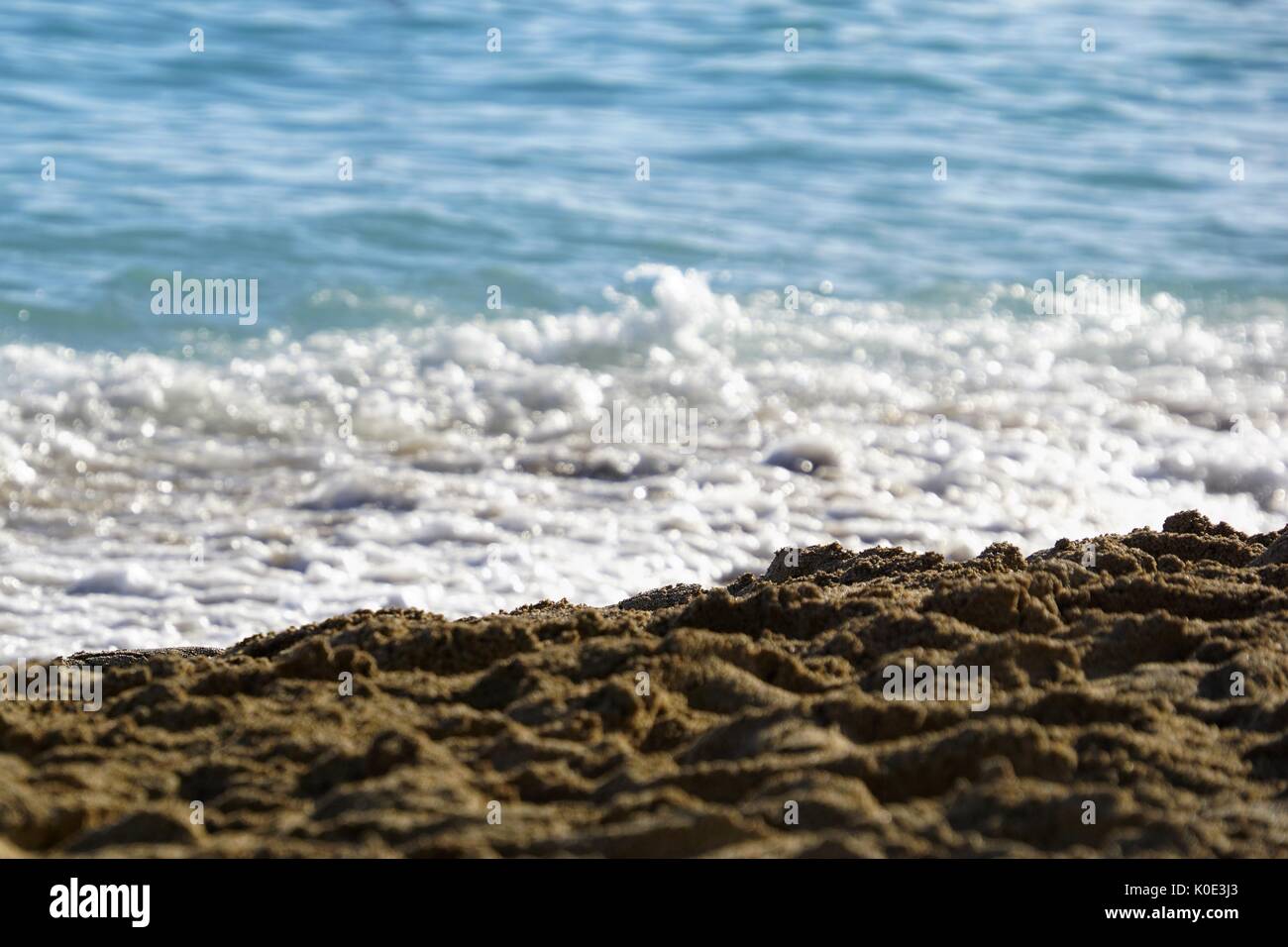 beach / seafront - blue sea, breaking wave, white water and sand Stock Photo