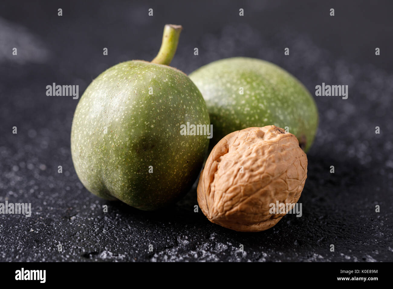Fresh green walnuts in the skin just from the tree. Walnuts on a black