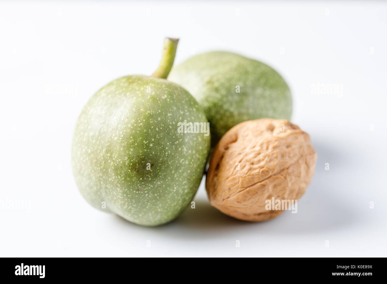 Fresh green walnuts in the skin just from the tree. Walnuts on a white