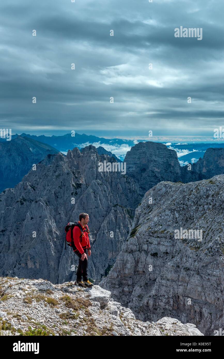 Pizzon, Monti del Sole, Dolomites, Veneto, Italy. Mountaineer on the summit of Pizzon. In the background the Monti del Sole Stock Photo