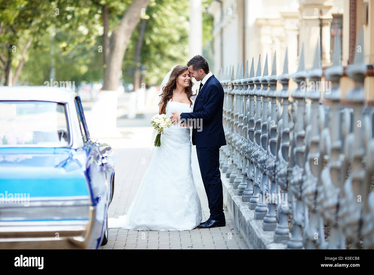 The bride and groom on the wedding day to the car Stock Photo - Alamy