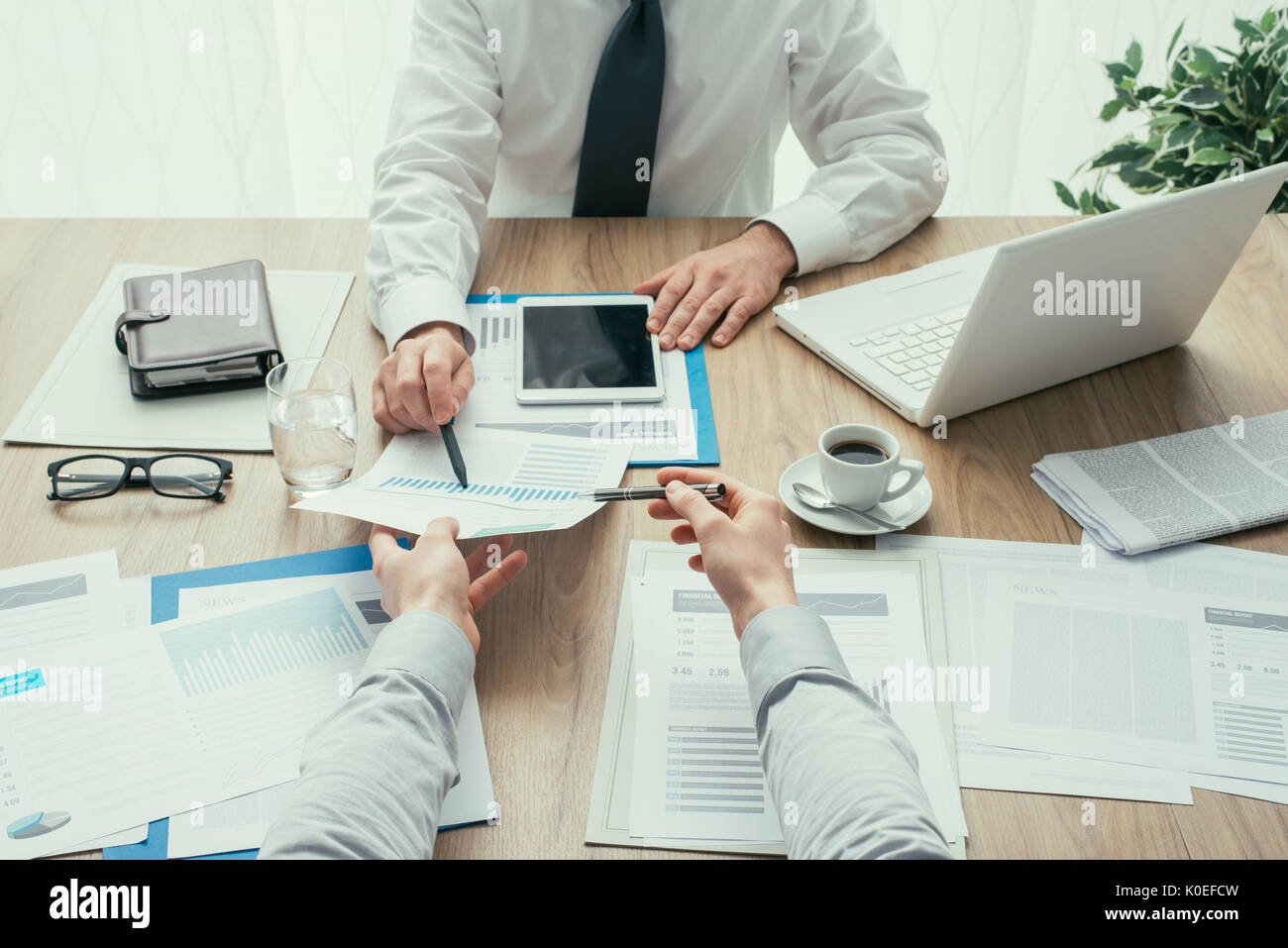 Business people having a meeting and working at office desk, they are analyzing financial reports, point of view shot Stock Photo
