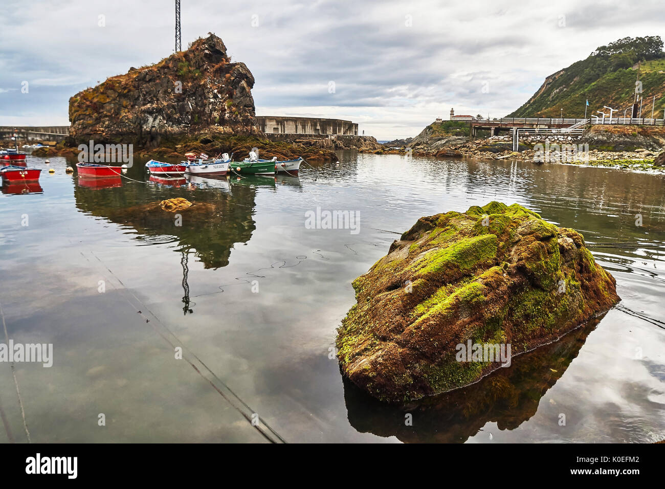 Little harbour for fishing boats at cloudy day whit clouds in the sky. Located in the Cudillero town. Cantabria. Stock Photo