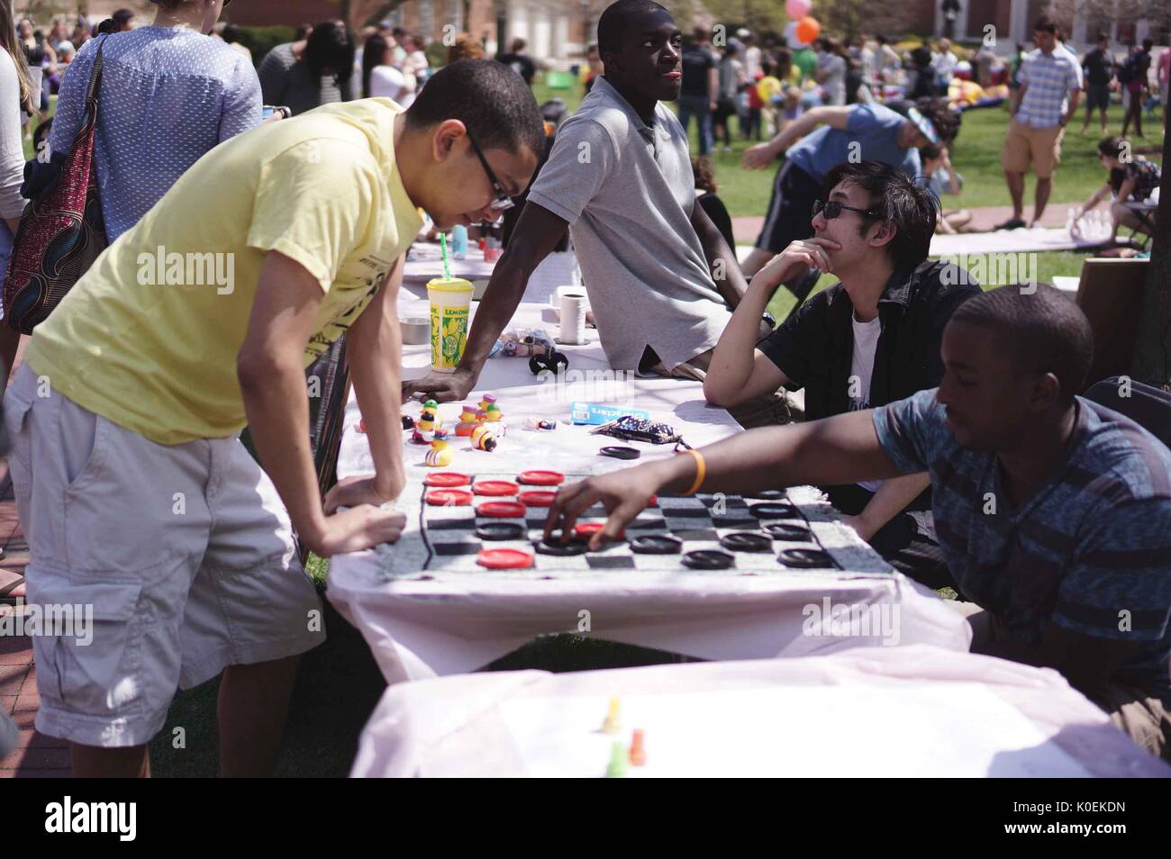 College students and members from the Johns Hopkins and Baltimore communities play games at stations set up for Spring Fair, an annual festival with music, food, shopping, and more that takes place every spring on the Homewood campus of the Johns Hopkins University in Baltimore, Maryland, 2014. Courtesy Eric Chen. Stock Photo