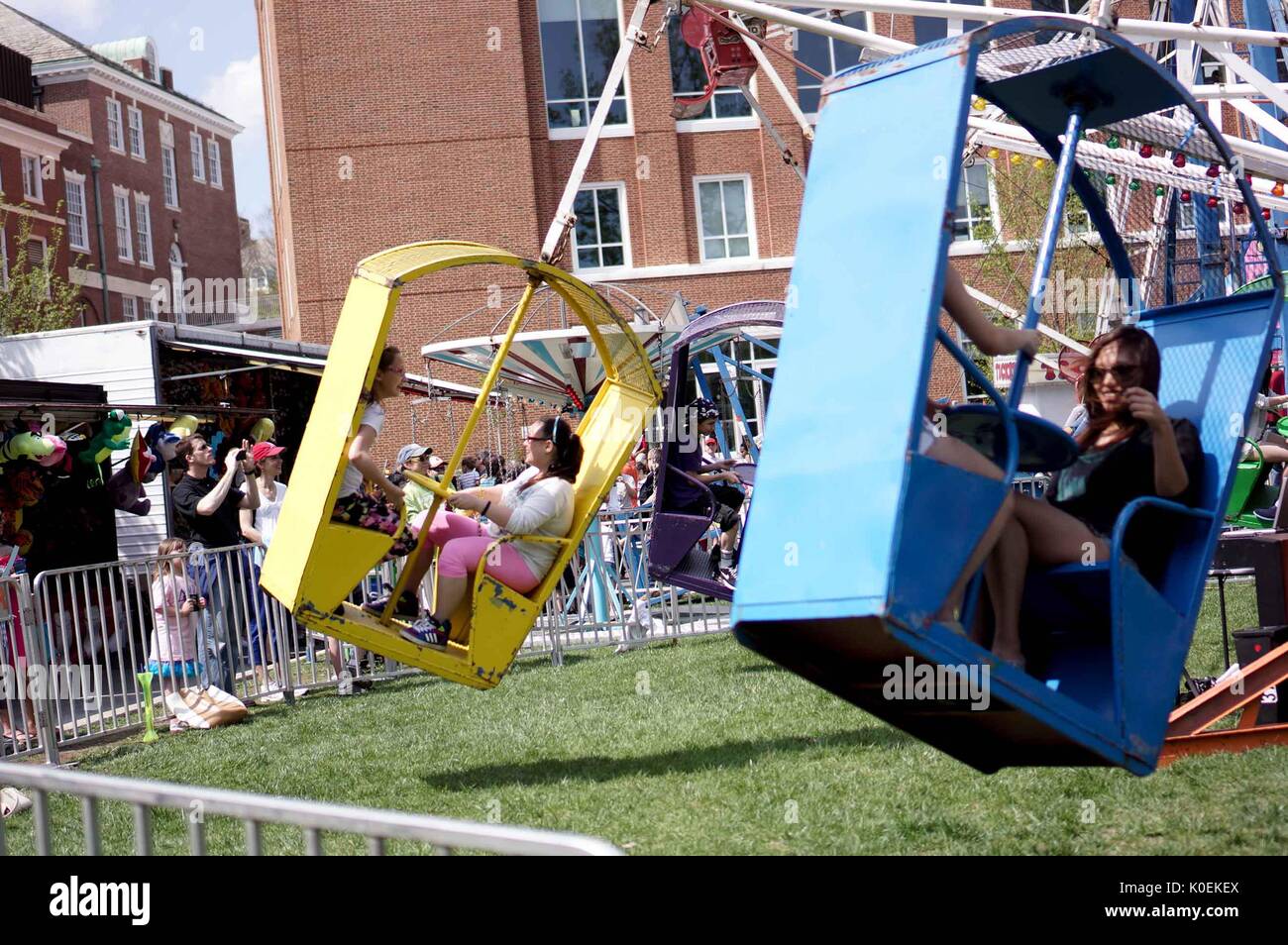 Action shot of carnival ride with children and adults, outside of Brody Learning Commons during Spring Fair, a student-run spring carnival at Johns Hopkins University, Baltimore, Maryland, April, 2014. Courtesy Eric Chen. Stock Photo