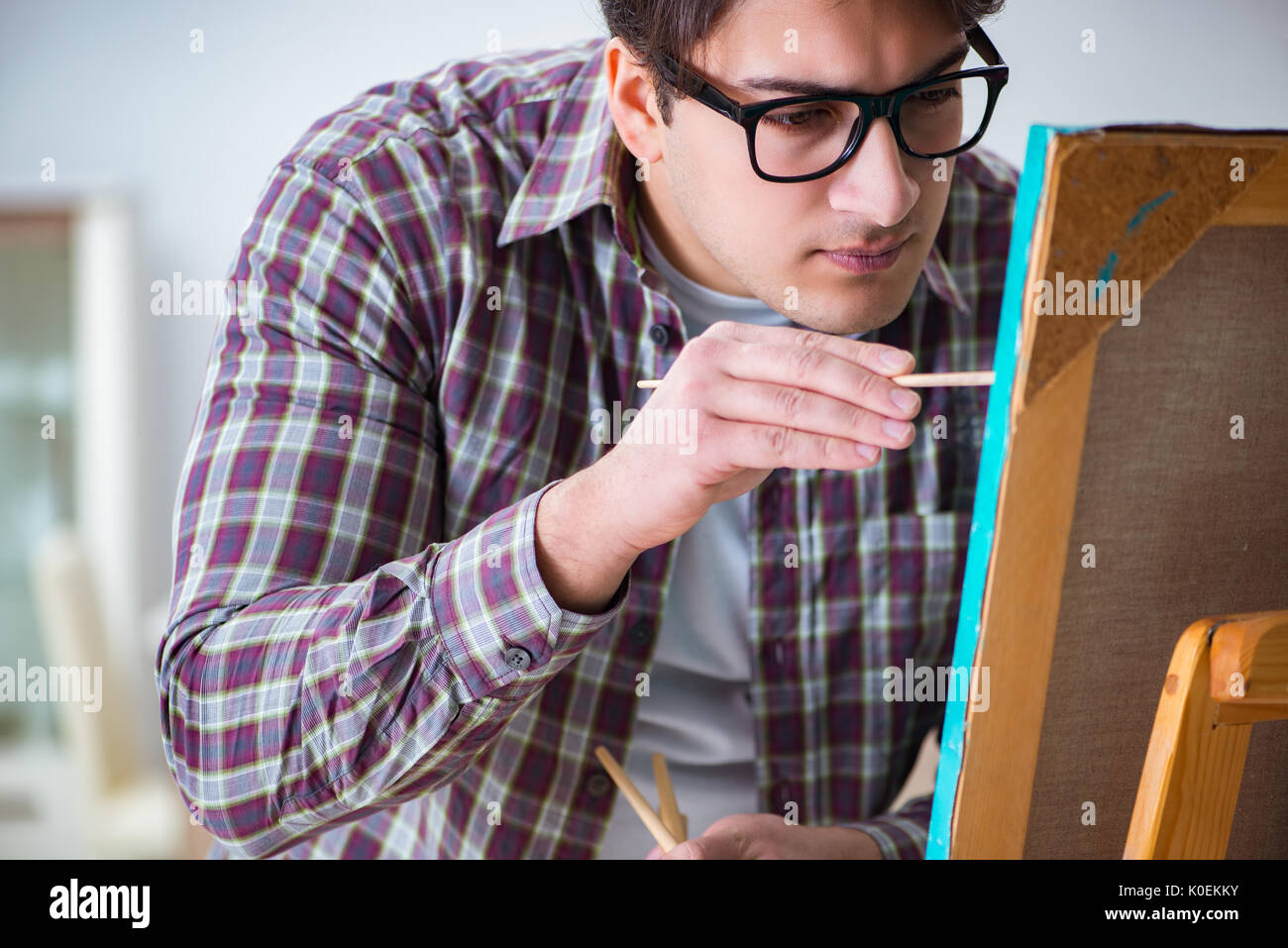 Young male artist drawing pictures in bright studio Stock Photo - Alamy