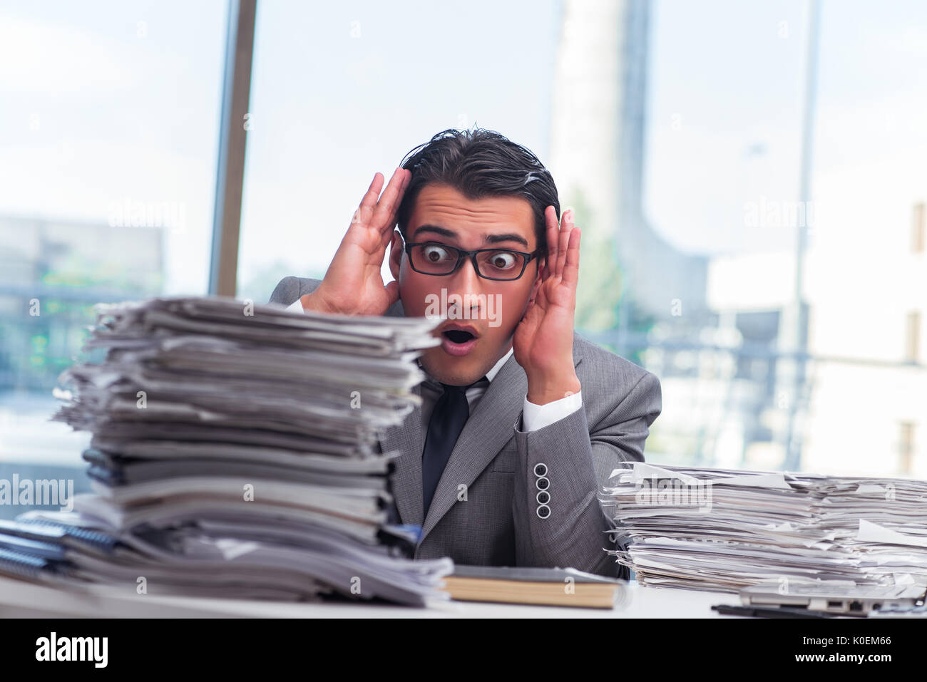 Busy angry businessman with heaps of paper Stock Photo - Alamy