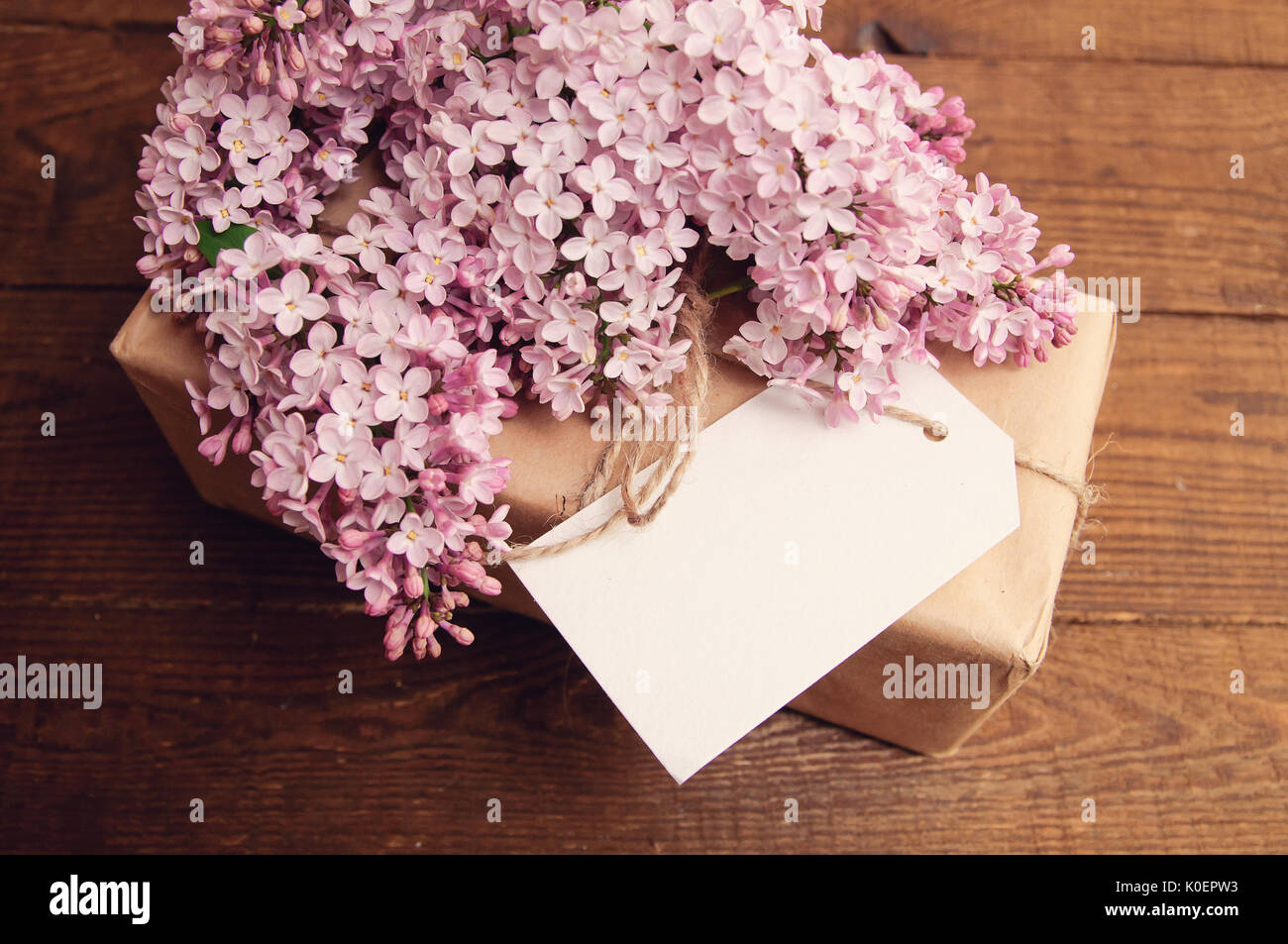 Gift wrapped with kraft paper on a wooden table, tied with a rope, with ...