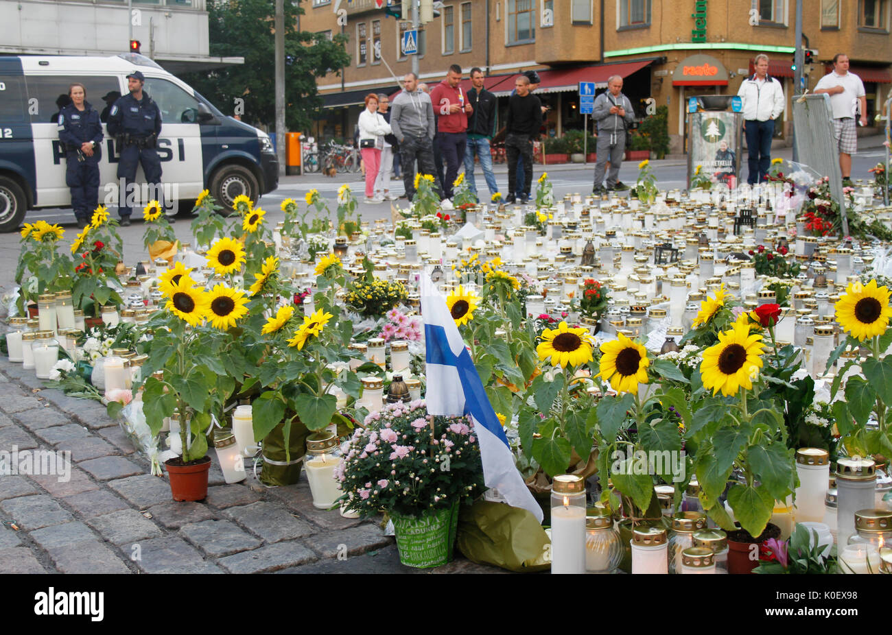 Turku, Finland. 22th Aug, 2017. Police safe guards the scene of the Turku knife attack where one of the two murders took place on 18th of August 2017. Four days after terrosristic rampage people are still bringing flowers and memorial candles for victims to Turku Central Market Square. Credit: Jukka Palm/Alamy Live news. Stock Photo