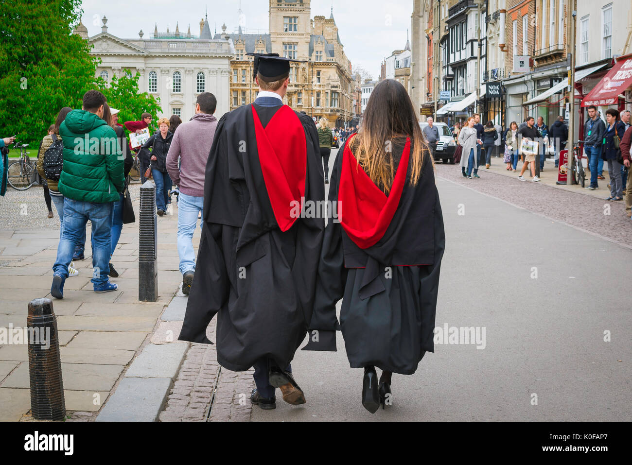Cambridge students, a Cambridge University tutor and undergraduate walk along King's Parade on their way to a graduation ceremony, England, UK. Stock Photo
