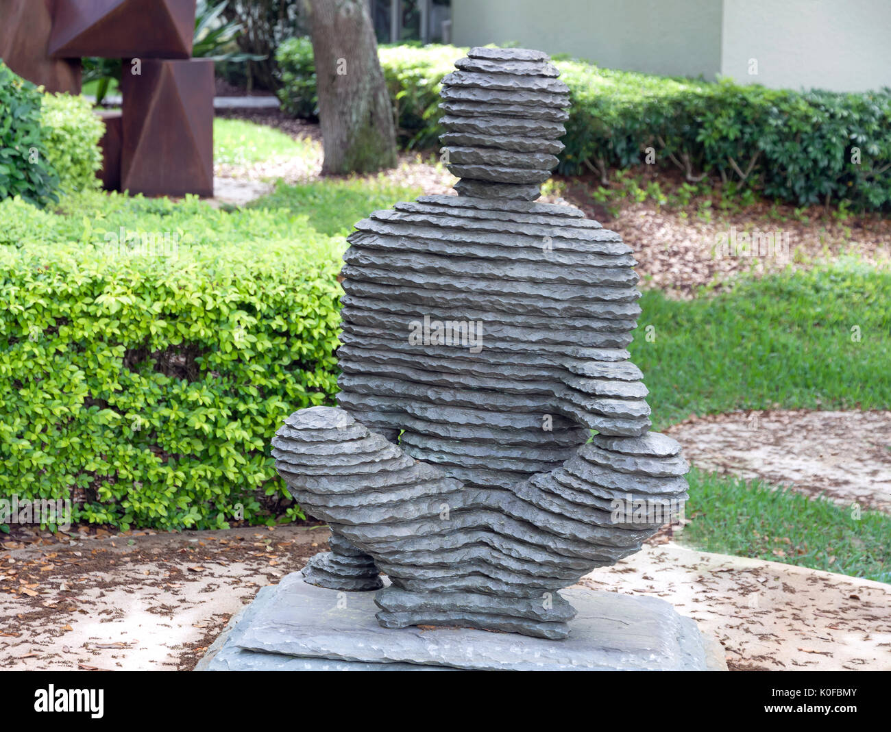 Figurative statue of a man sitting (titled 'David of bronze & bluestone) by sculptor Boaz Vaadia. Stock Photo