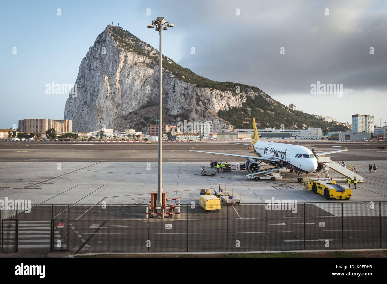 An aircraft on the tarmac at Gibraltar International Airport with Gibraltar Rock seen in the background. Stock Photo