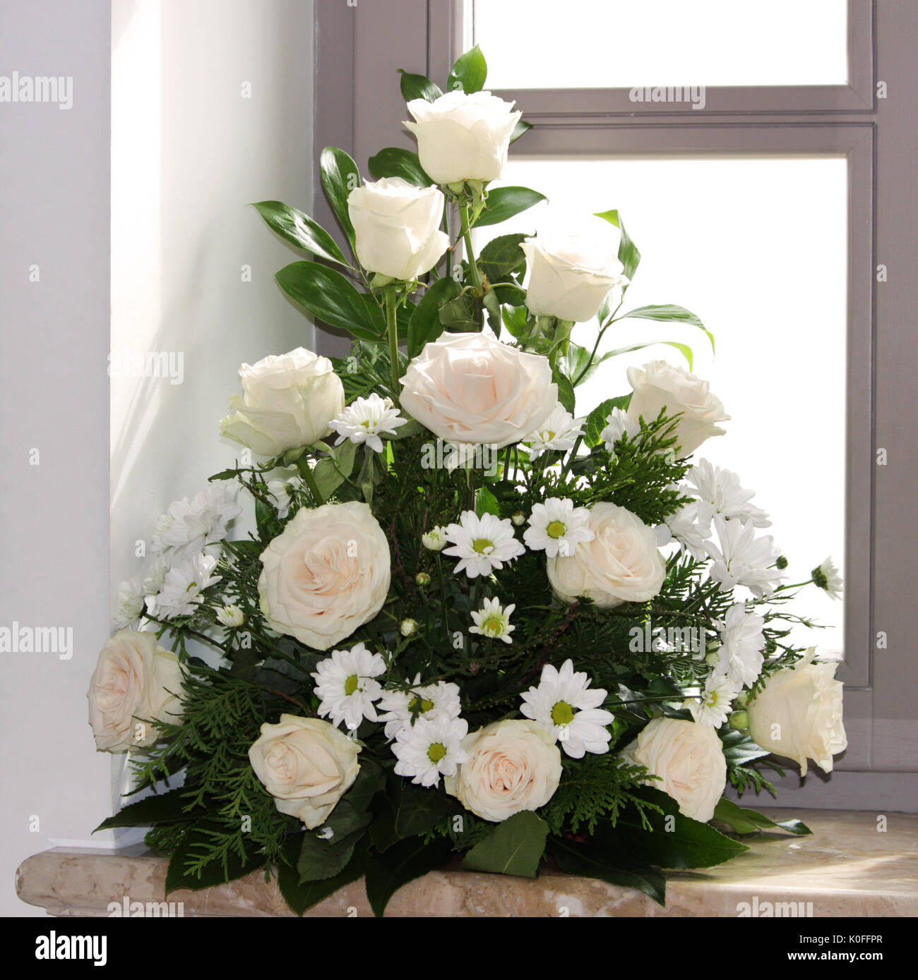 A flower bouquet of cream roses and chrysanthemums on the windows in the  church as a decoration of the holiday. Professional floristics Stock Photo  - Alamy, image size:1300x1389