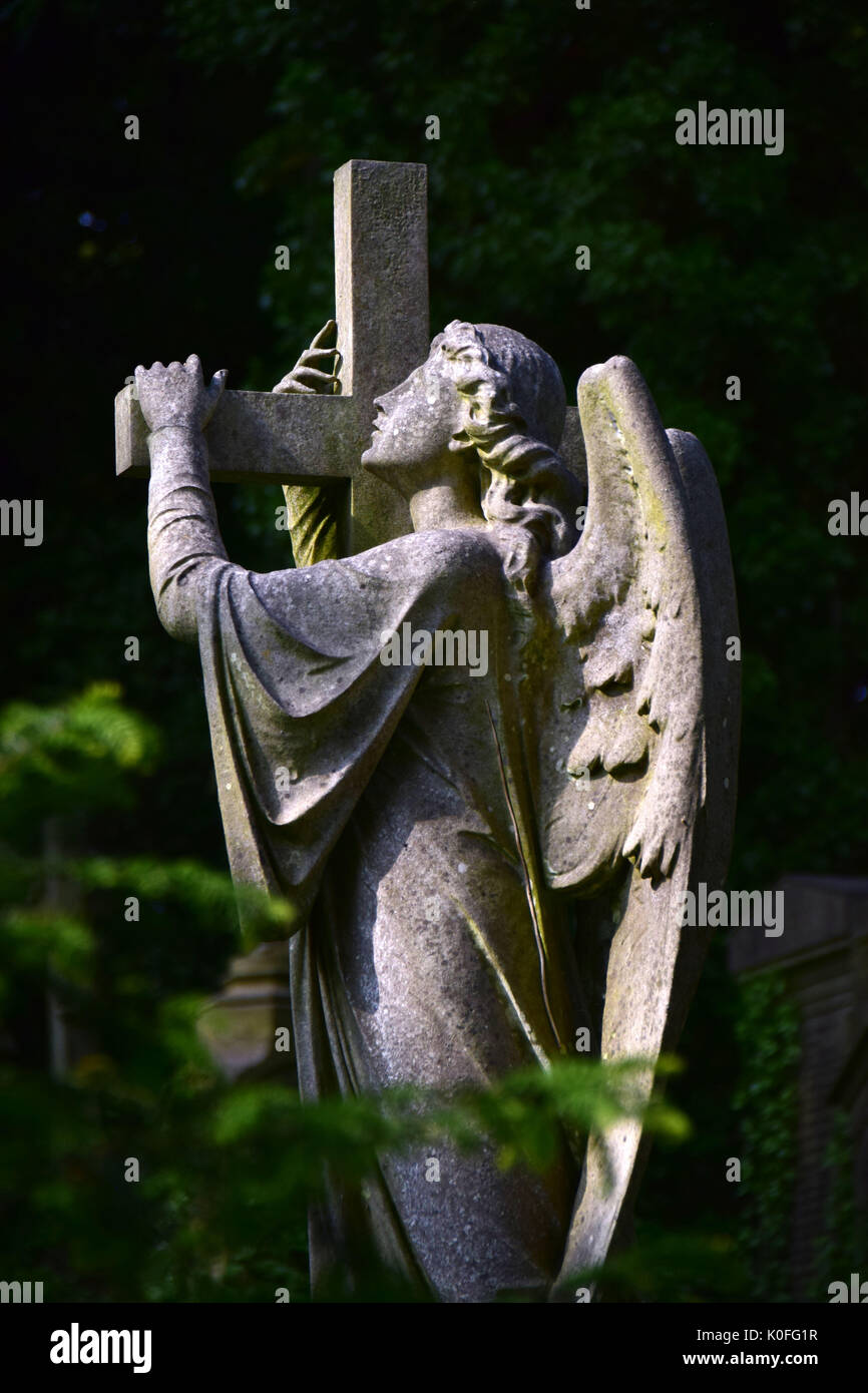 an angel holding cross in Highgate cemetery London Stock Photo - Alamy