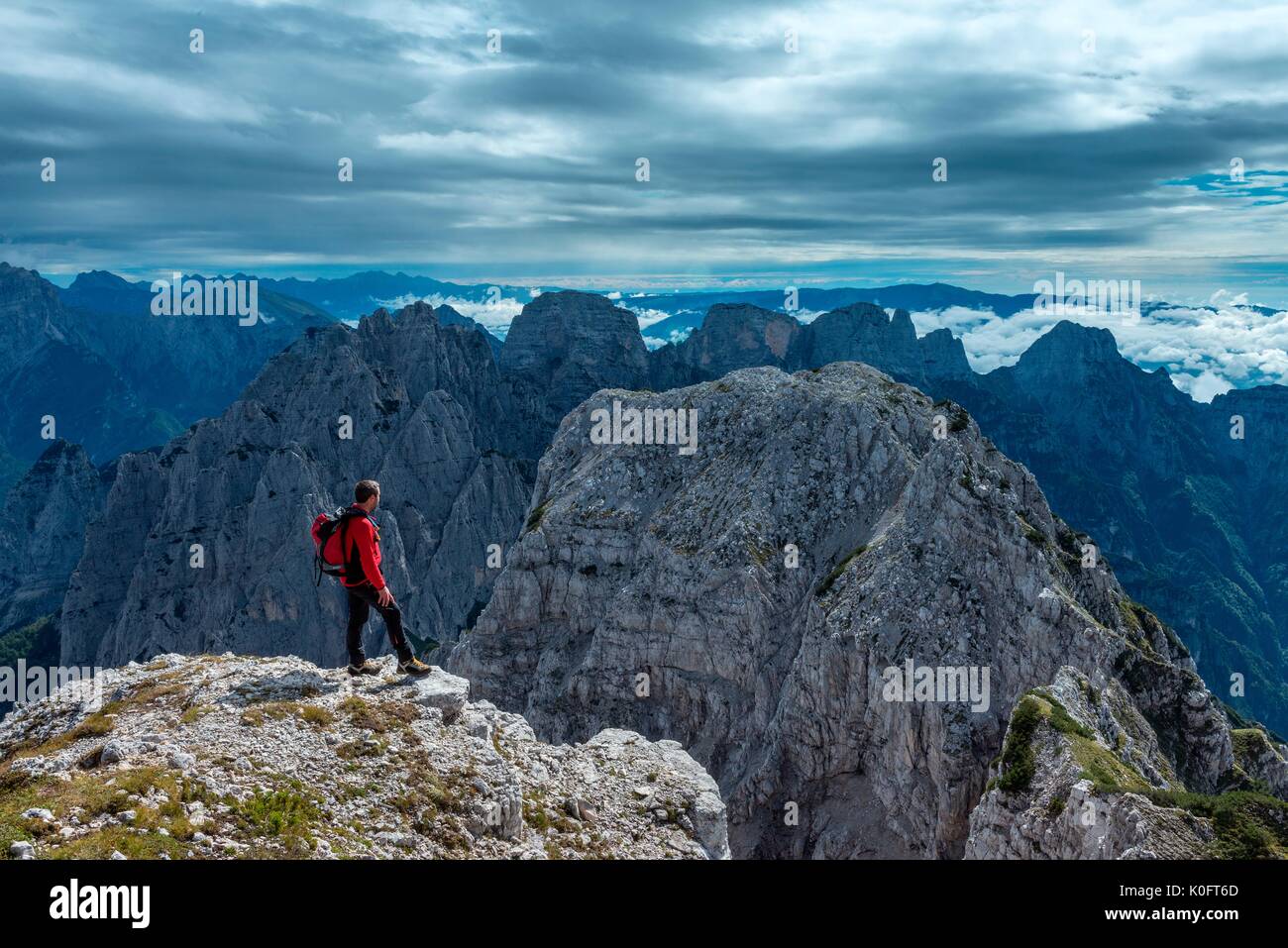 Pizzon, Monti del Sole, Dolomites, Veneto, Italy. Mountaineer on the summit of Pizzon. In the background the Monti del Sole Stock Photo