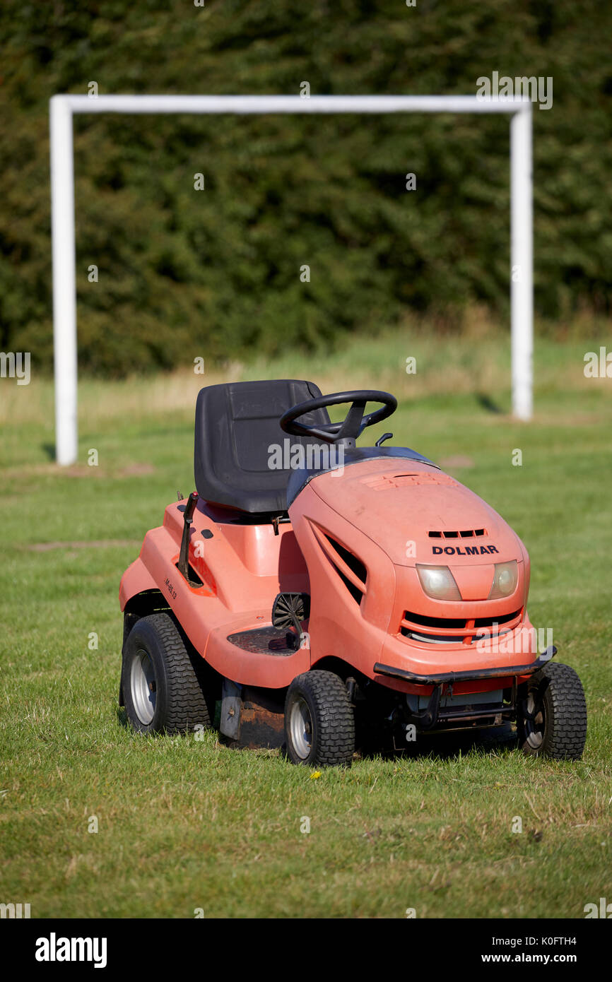 Ride on grass cutting lawnmower at a sports ground Stock Photo