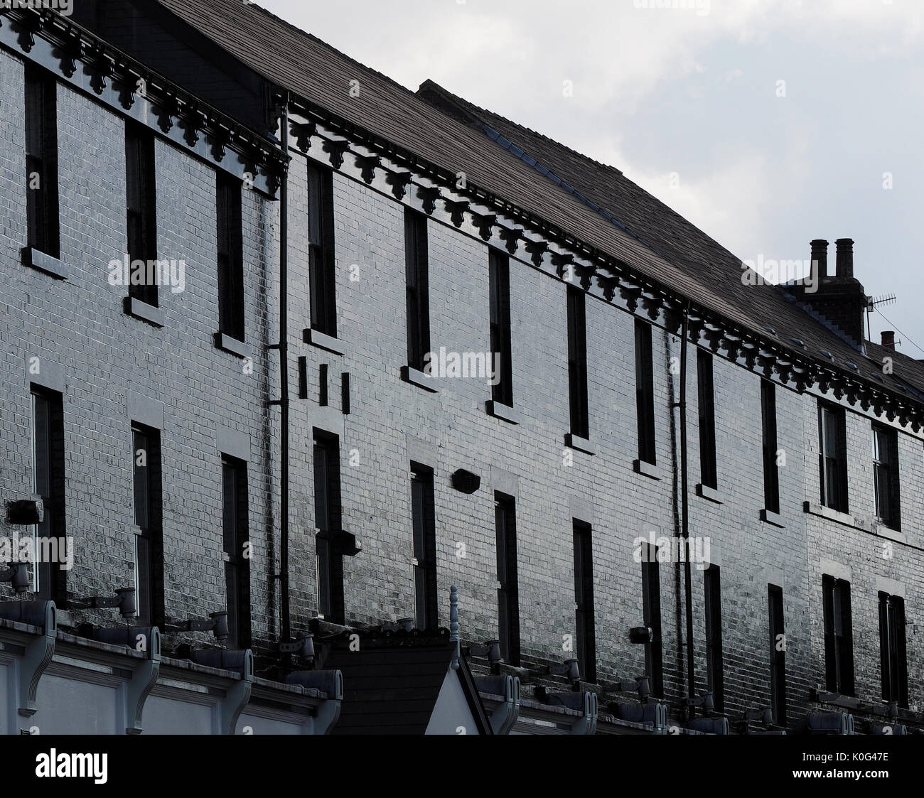surreal effect of sunshine on facade of black painted terrace buildings in Sheffield, South Yorkshire, England, UK Stock Photo