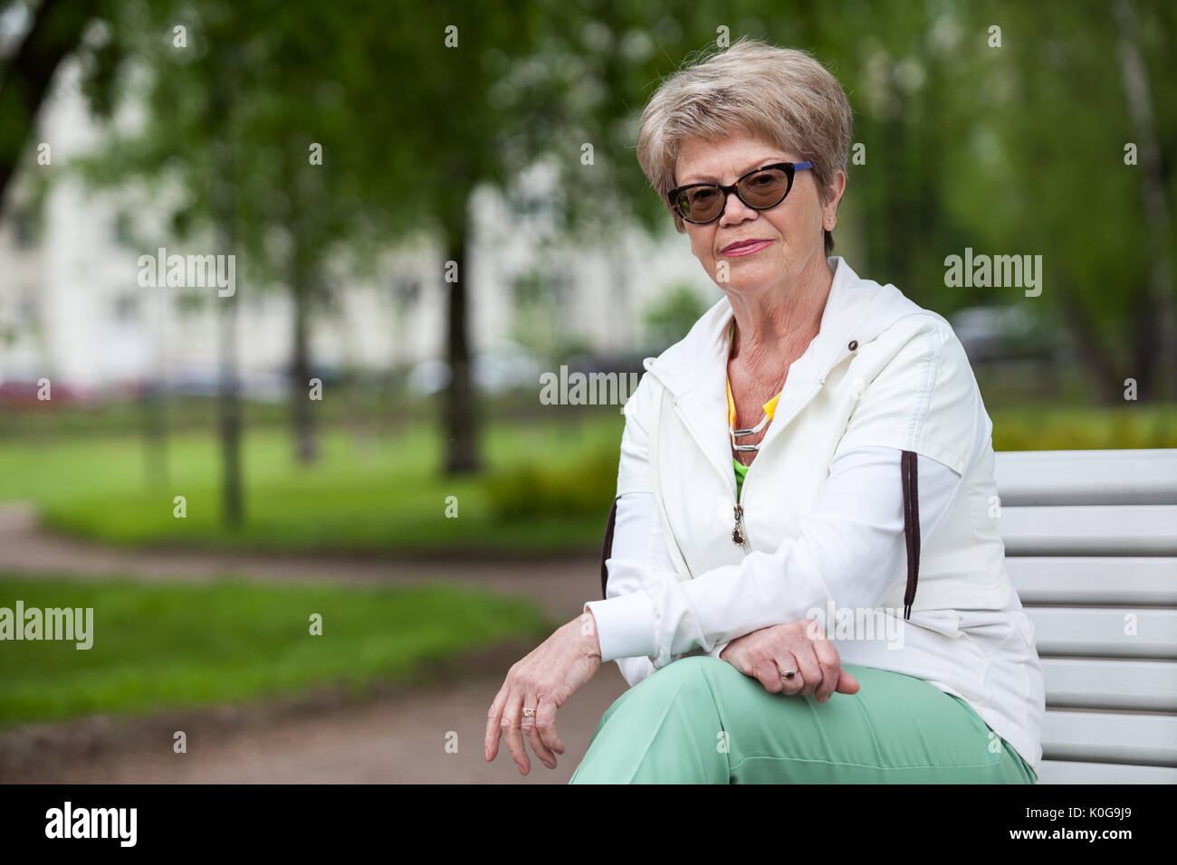 Mature woman thinking sitting bench hi-res stock photography and images ...