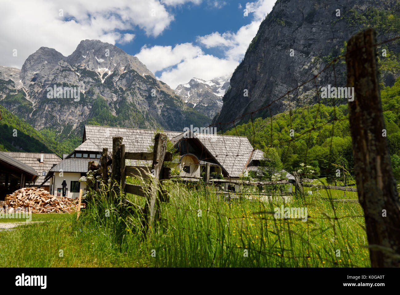 Tourist information center and firewood and fence in alpine village of Trenta with Pihavec peak Triglav National Park Slovenia Stock Photo