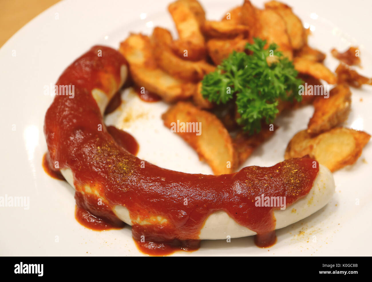 Weisswurst or German White Sausage with Curry Ketchup and Fried Potatoes, Selective Focus and Blurred Background Stock Photo