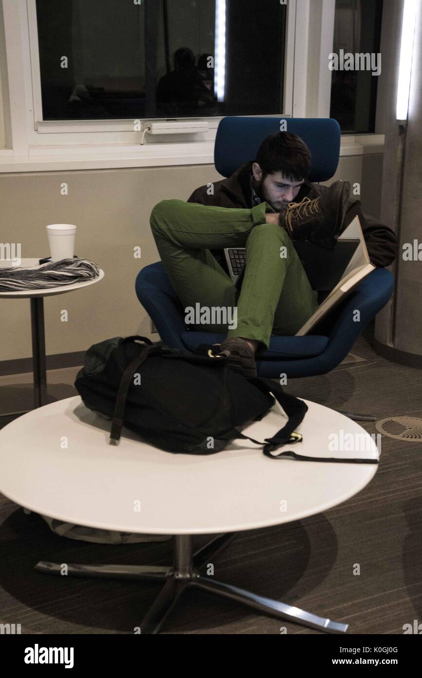 A college student studies late at night in the Brody Learning Commons, a library and study space on the Homewood campus of the Johns Hopkins University in Baltimore, Maryland, 2015. Courtesy Eric Chen. Stock Photo