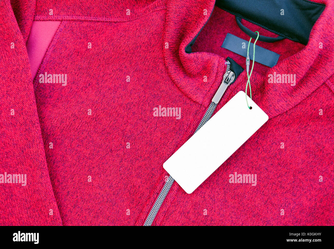 White blank clothing label tag on a new red jacket with zipper Stock Photo