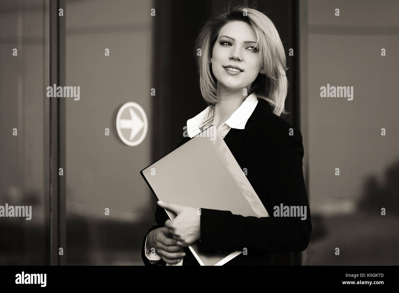 Happy young business woman with a folder at office building Stock Photo ...