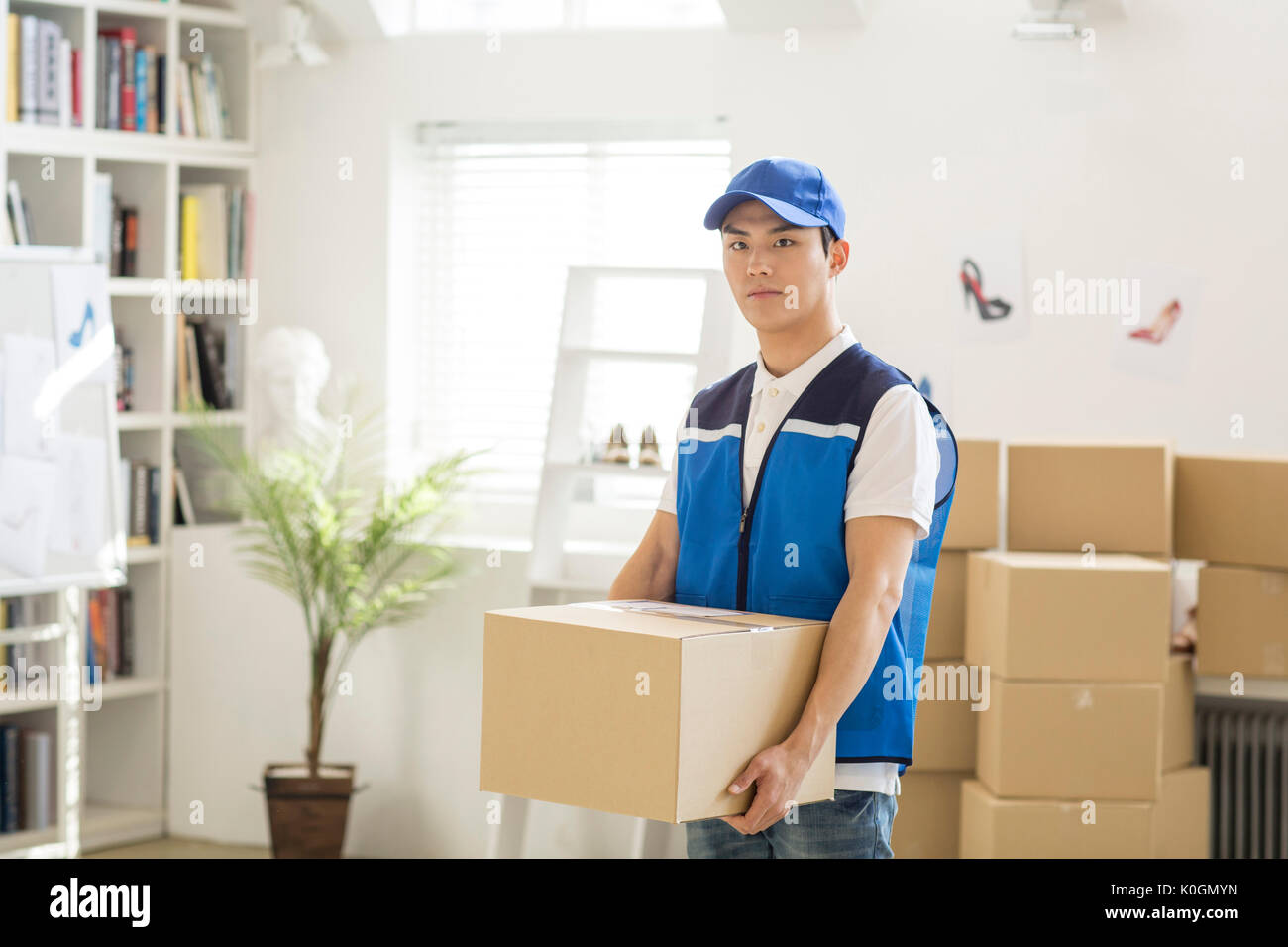 Young delivery man holding a box Stock Photo