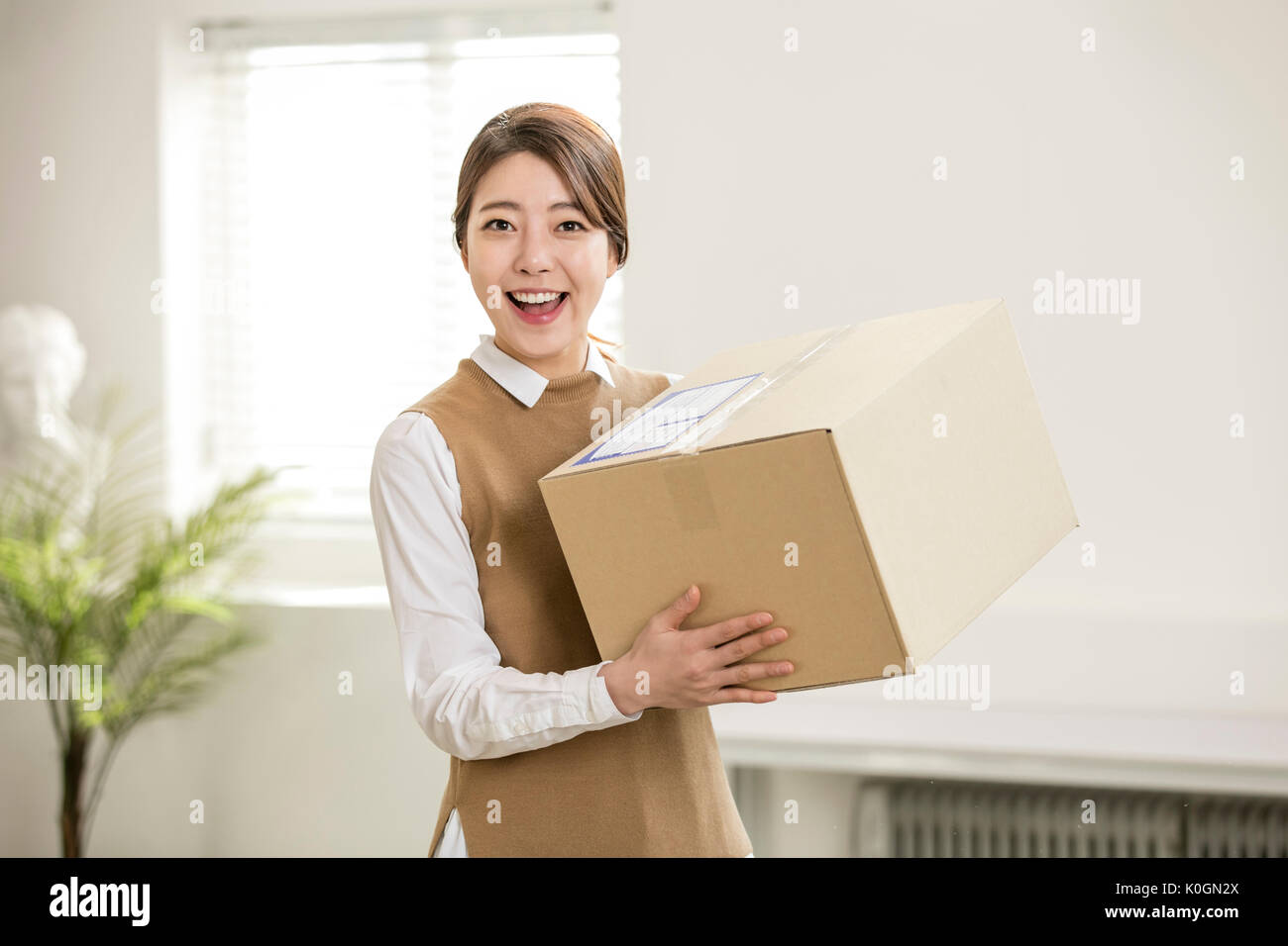 Young smiling woman with delivery box Stock Photo