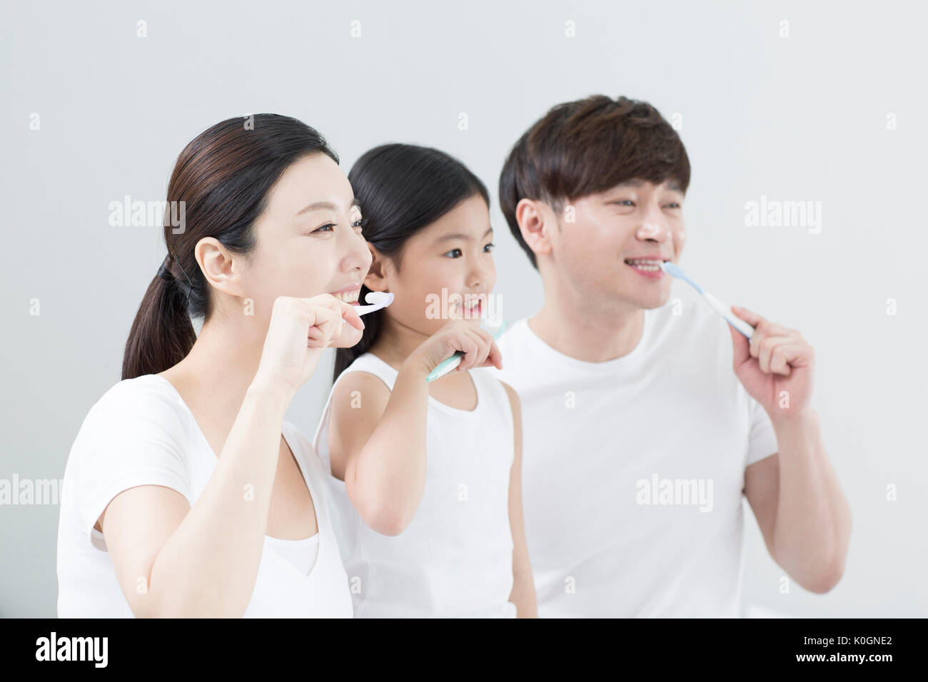 Portrait of smiling family brushing their teeth Stock Photo