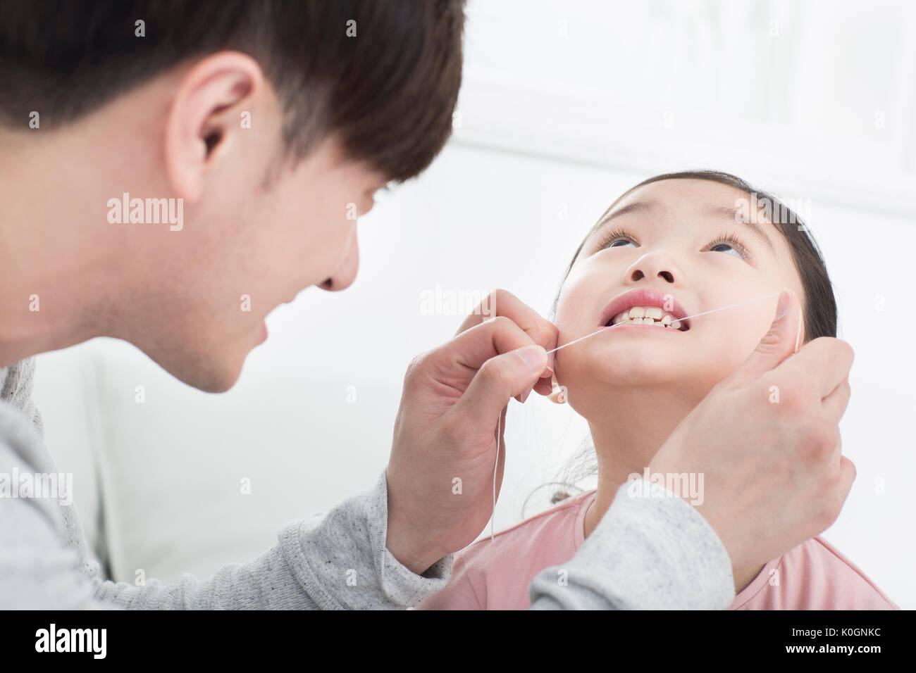 Portrait of father and daughter using dental floss Stock Photo