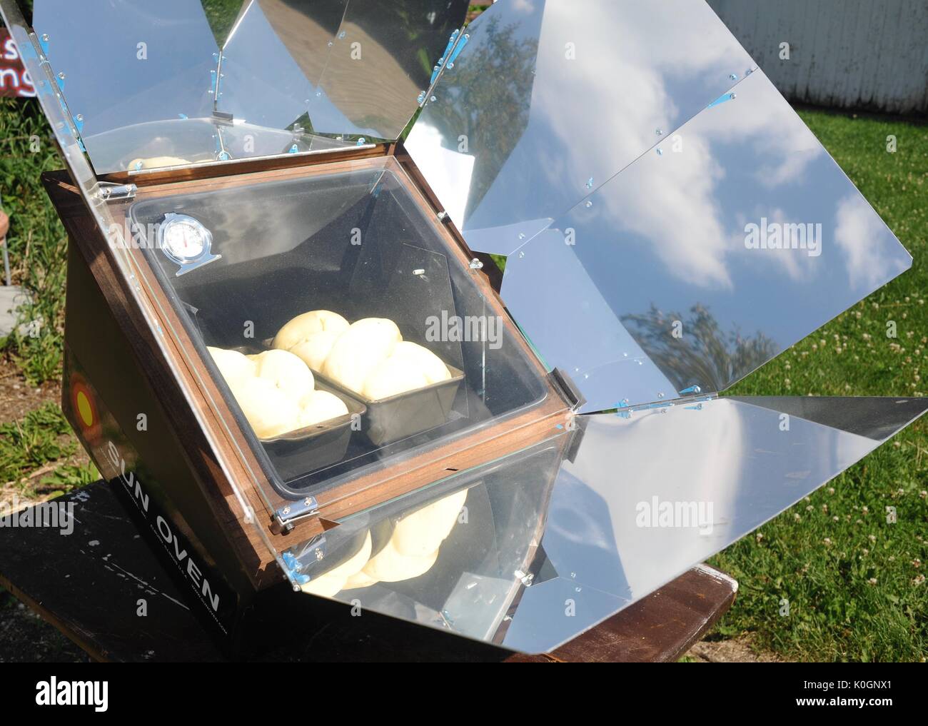 Baking two loaves of fresh bread in a sun oven, where heat is provided only by the sunshine hitting the airtight oven. Stock Photo