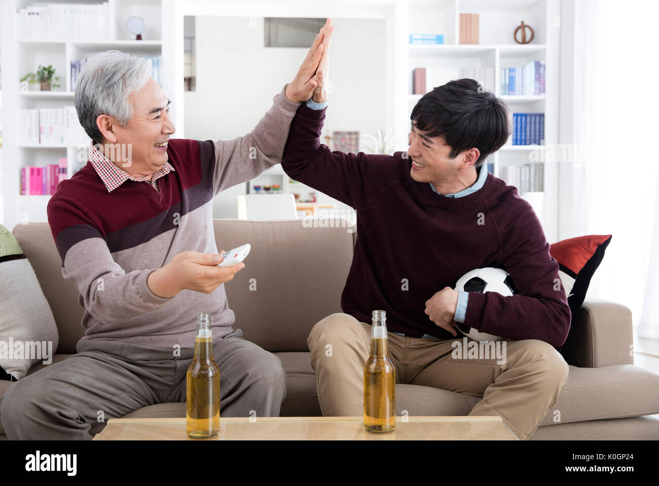 Smiling senior man and his young son slapping high five Stock Photo