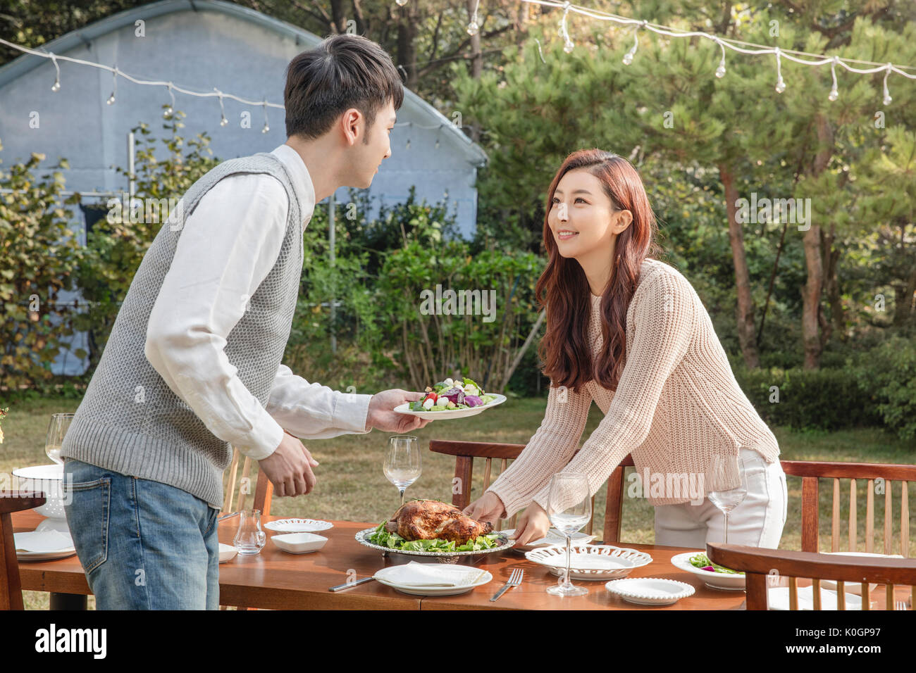 Young smiling couple preparing for a party at garden Stock Photo