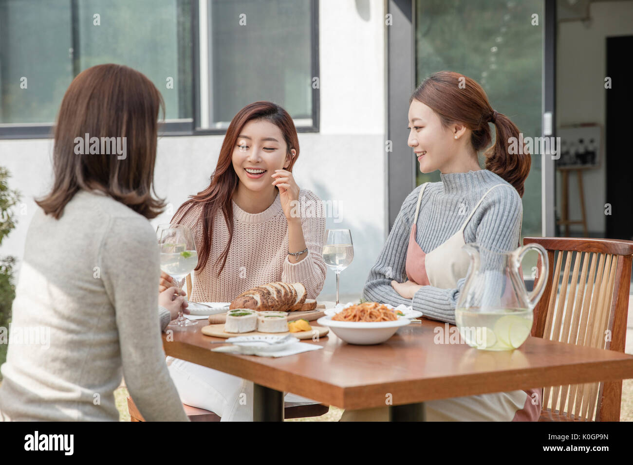 Three young smiling women having a party at garden Stock Photo - Alamy