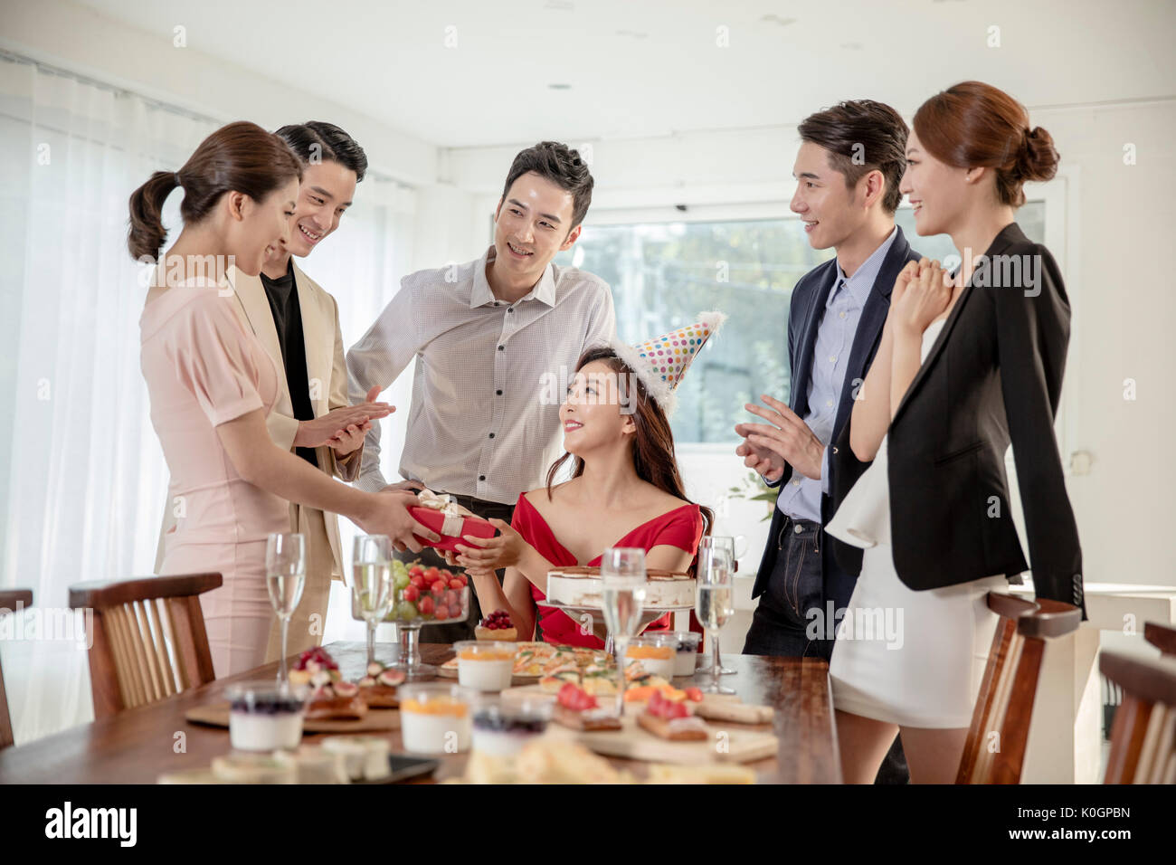 Young smiling friends having a birthday party for a woman Stock Photo