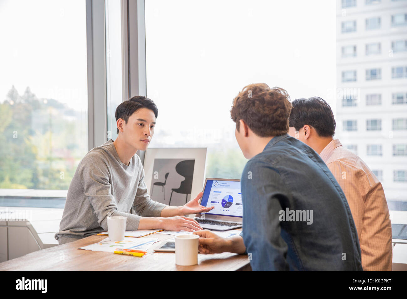 Three businessmen having a meeting at office Stock Photo