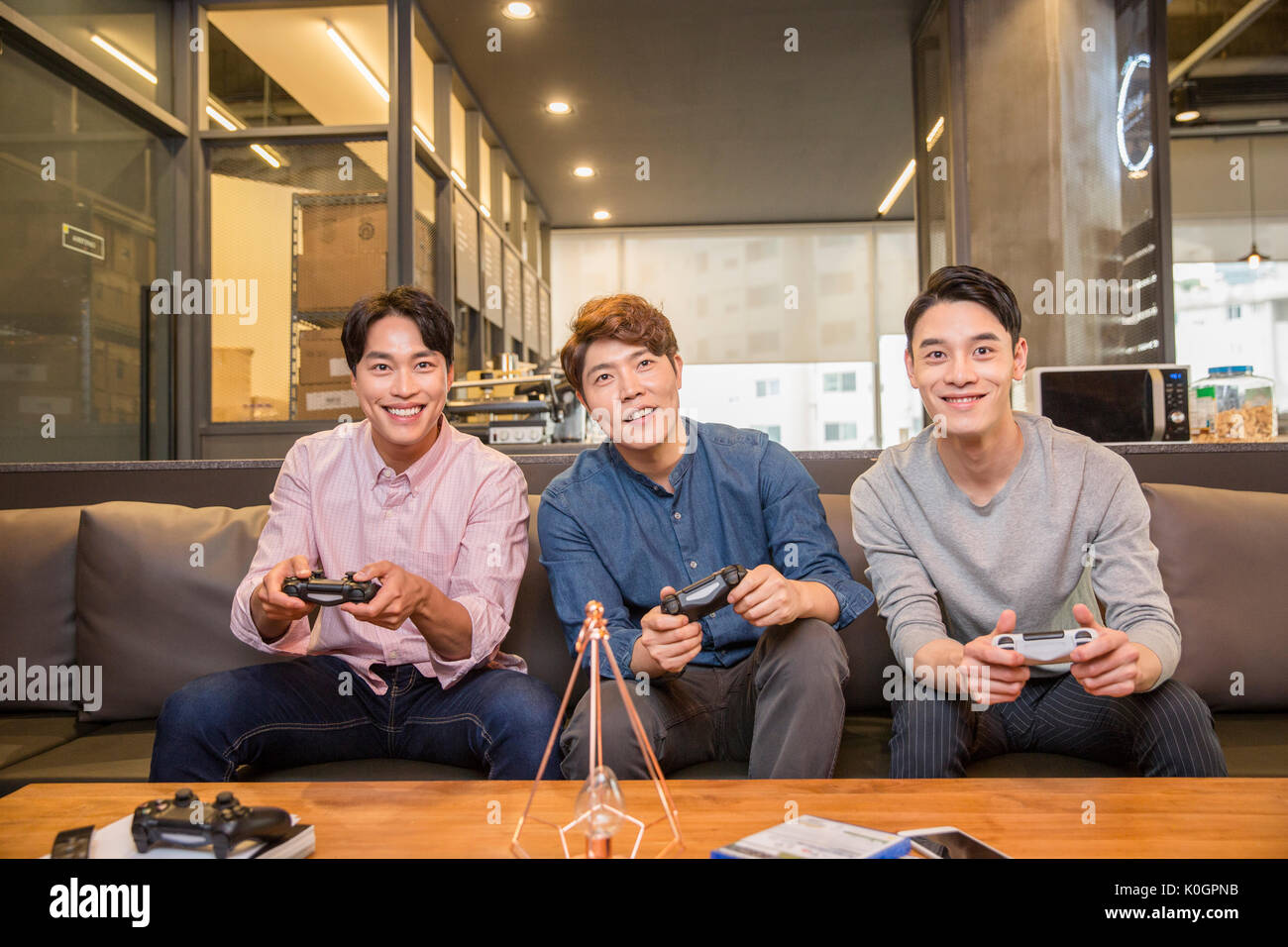 Three smiling businessmen enjoying video games Stock Photo